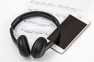 Des écouteurs, un smartphone et une partition de musique