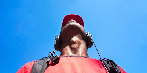 Un homme, sac au dos, écoutant de la musique avec un casque