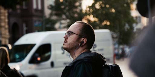 Un homme dans la rue portant des casques aux oreilles
