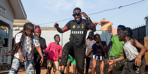 Eddy Kenzo dansant dans la rue avec des fans