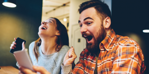 Un homme et une femme en train de regarder des vidéos sur un smartphone