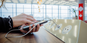 Une personne utilisant une borne USB de recharge dans un espace public